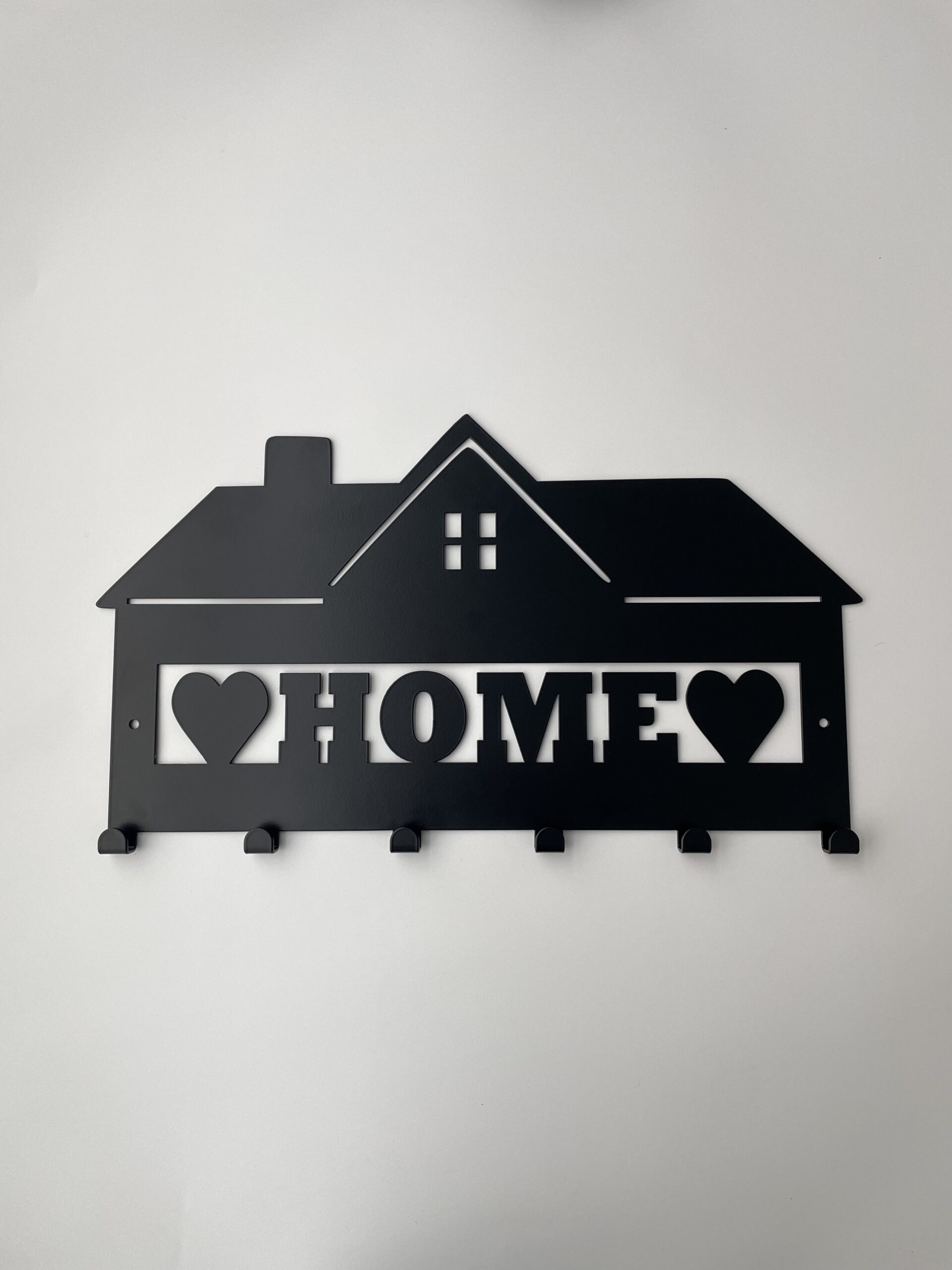 Kovový nástěnný věšák ve tvaru domku s nápisem HOME